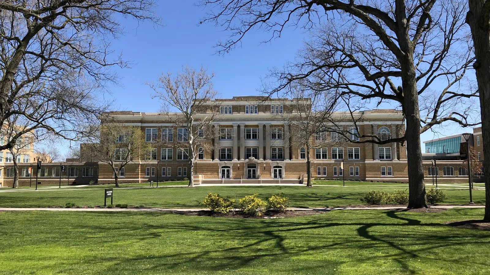 University Hall across a sunny lawn and bare trees at Bowling Green State University in Bowling Green, Ohio