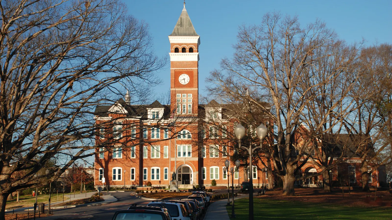 Tillman Hall and its brick clock tower behind bare winter trees at Clemson University