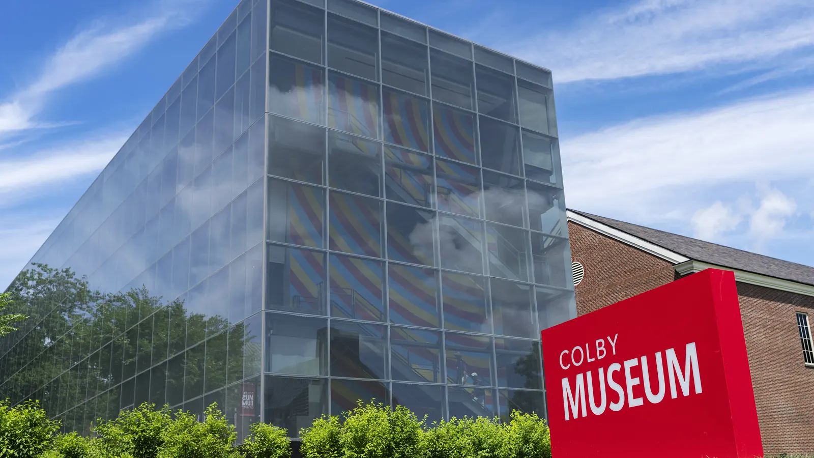 The glass pavilion of the Colby College Museum of Art and its red Colby Museum sign, in Waterville, Maine