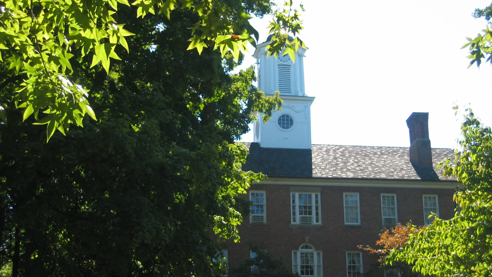 Cutler Hall and its white cupola behind the trees at Ohio University in Athens, Ohio
