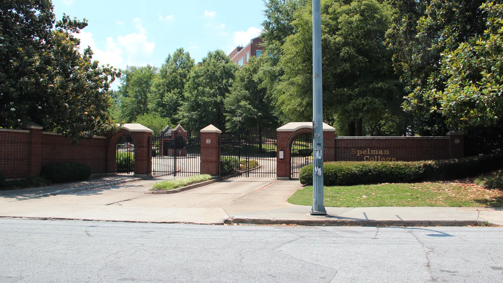 Brick gates and a low brick wall lined with trees at the entrance to Spelman College in Atlanta, Georgia