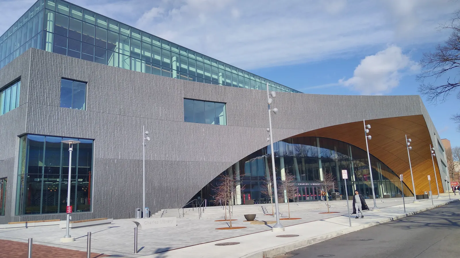 Charles Library, a stone and glass building with an arched wooden entrance, at Temple University