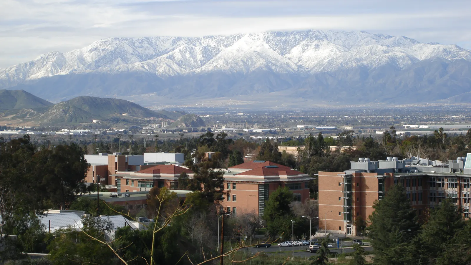 The UC Riverside campus below snow-capped mountains, seen from the botanic gardens in Riverside, California