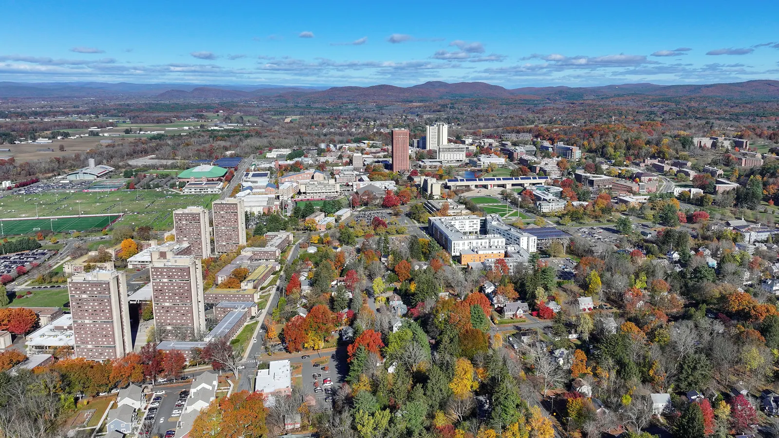 Aerial view of the University of Massachusetts Amherst campus in autumn, with the Southwest Residential Area in front and the W. E. B. Du Bois Library at center