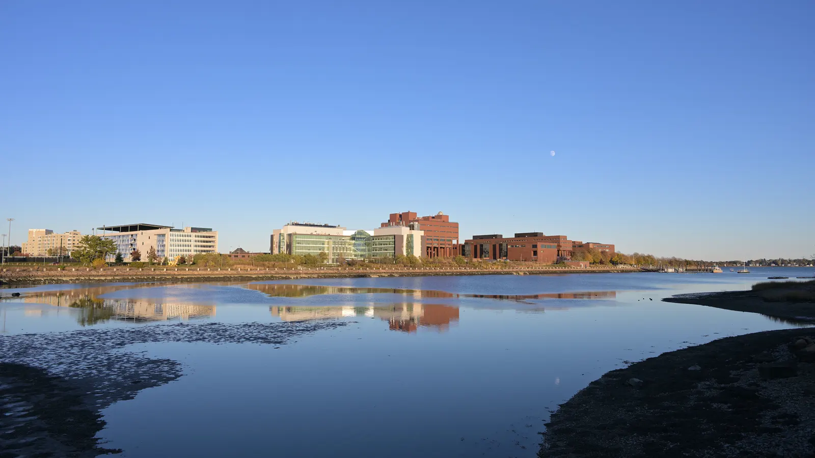 The UMass Boston campus on Columbia Point seen across the water from Morrissey Boulevard in Boston, Massachusetts