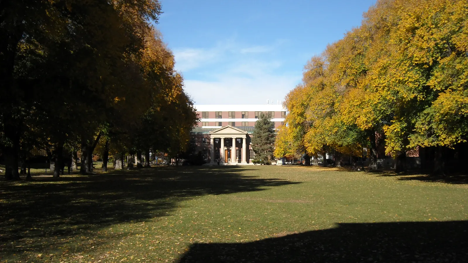The tree-lined Quad in autumn, looking toward a columned hall at the University of Nevada, Reno