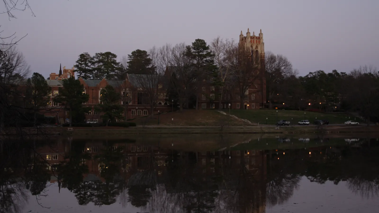 Collegiate Gothic buildings and a tower reflected in Westhampton Lake at dusk, University of Richmond, Virginia