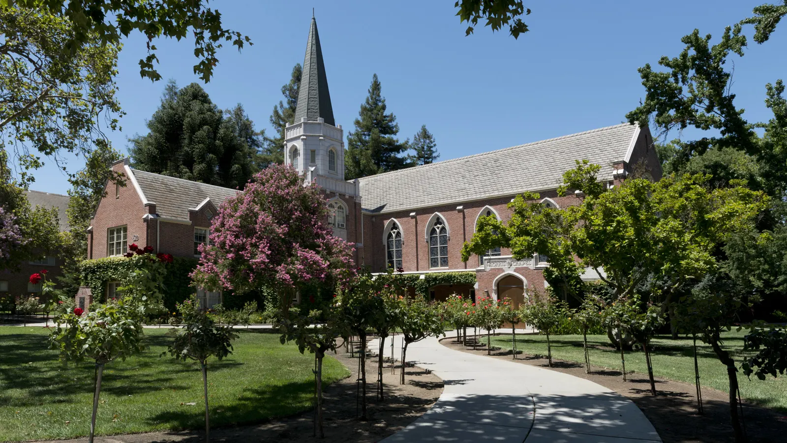 Morris Chapel, a brick chapel with a white steeple, behind a tree-lined walk at the University of the Pacific in Stockton, California