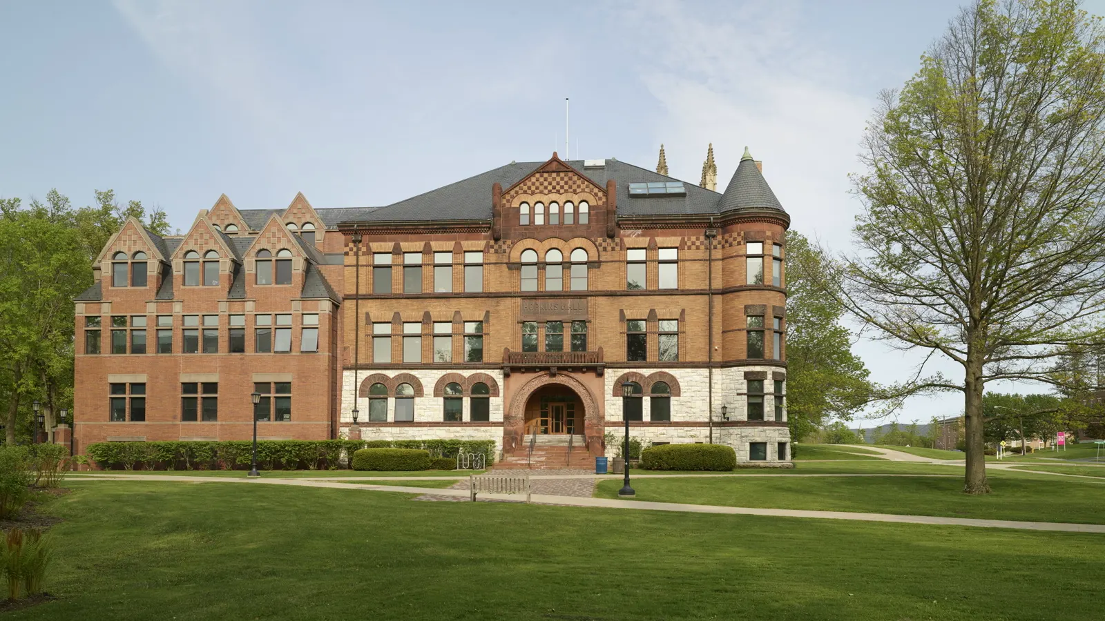 Hopkins Hall, a red brick building with an arched stone entrance, behind a green lawn at Williams College in Williamstown, Massachusetts